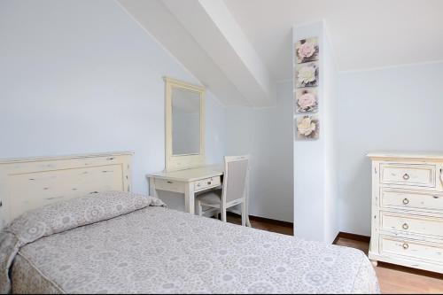 a bedroom with a bed and a desk and a mirror at Hotel Risi in Colico
