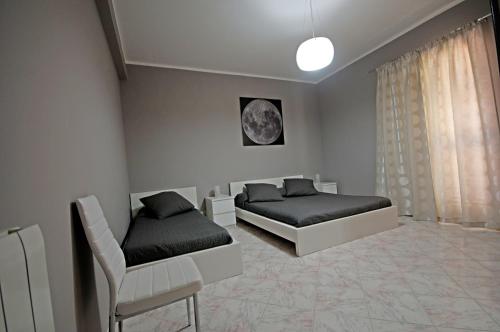 a bedroom with two beds and a chair at Kosmos in Siracusa