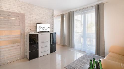 a living room with a stove and a wall at Aparthotel Koroni Home in Raszyn