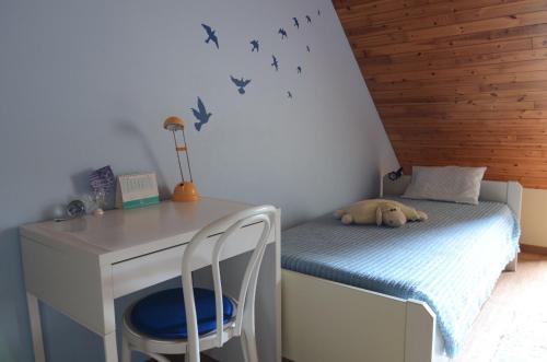 a bedroom with a bed and a desk with a dog sleeping on it at B&B Vanderstraeten-Bryxis in Grimbergen