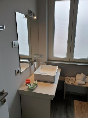 een badkamer met een wastafel en een spiegel bij Camomilla B&B in Alba