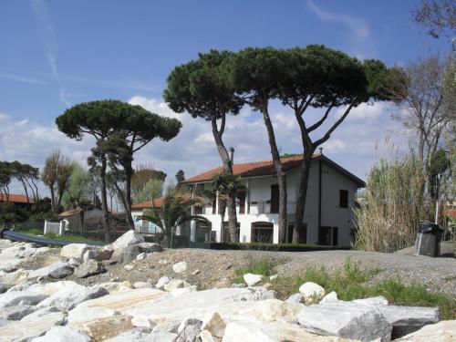 a house with trees and rocks in front of it at Residence Pax in Fiumaretta di Ameglia