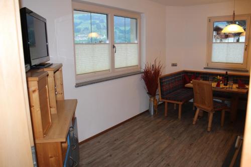 a living room with a dining room table and a television at Haus Markus in Fügen