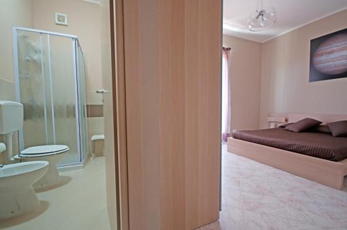 a bedroom with a bed and a bathroom with a toilet at Kosmos in Siracusa