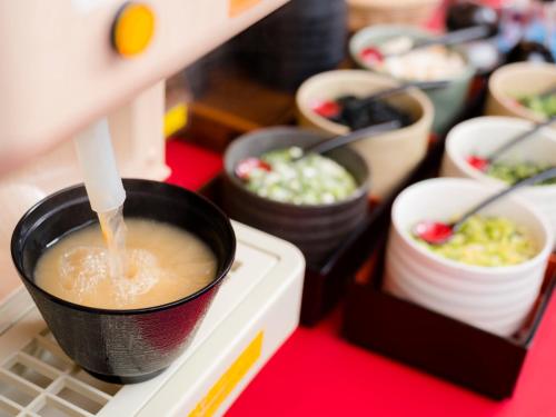 a row of cups of food on a shelf at SUPER HOTEL Tokyo Akabane Station Higashiguchi Ichibangai in Tokyo