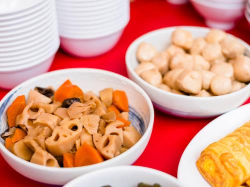 a table topped with bowls of food and plates at SUPER HOTEL Tokyo Akabane Station Higashiguchi Ichibangai in Tokyo