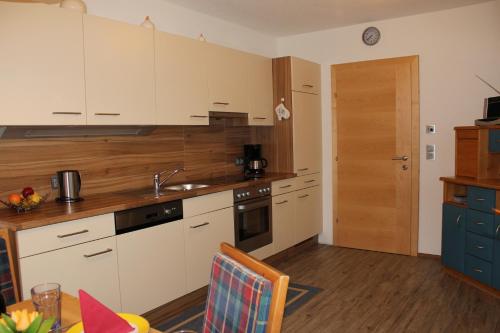 a kitchen with white cabinets and a wooden counter top at Haus Markus in Fügen