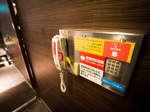 a phone is attached to a wall in an elevator at SUPER HOTEL Tokyo Akabane Station Higashiguchi Ichibangai in Tokyo