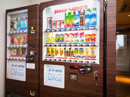 a vending machine filled with lots of bottles of soda at SUPER HOTEL Tokyo Akabane Station Higashiguchi Ichibangai in Tokyo