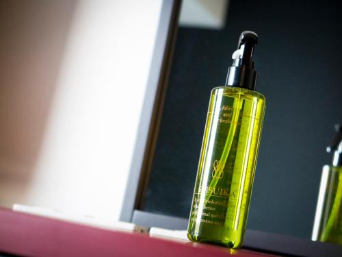 a green bottle of soap sitting on a bathroom counter at SUPER HOTEL Tokyo Akabane Station Higashiguchi Ichibangai in Tokyo