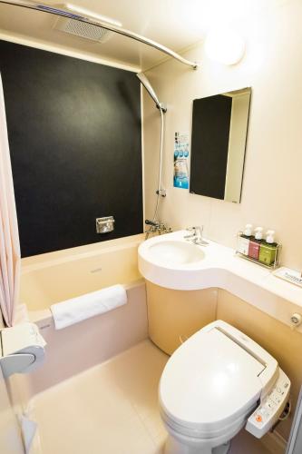 a small bathroom with a toilet and a sink at SUPER HOTEL Tokyo Akabane Station Higashiguchi Ichibangai in Tokyo