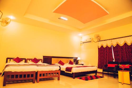 a hotel room with two beds in a room at KSTDC Hotel Mayura Chalukya, Badami in Badami