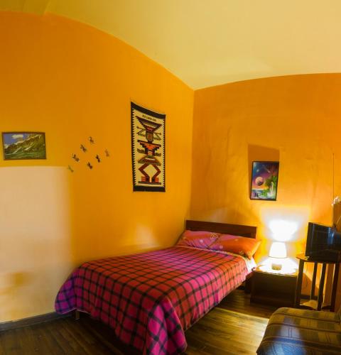 a bedroom with a bed in a room with yellow walls at La Querencia in Cuenca