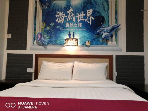 a bedroom with a bed with a poster on the wall at Mega Inn in Kuching