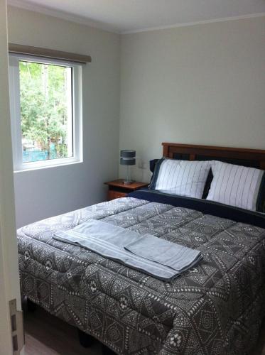 a bedroom with a large bed with a window at Refugio de Paz y Naturaleza en Pucón in Pucón