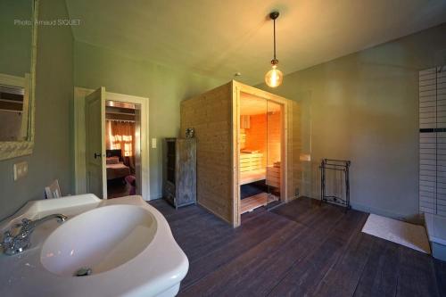 a bathroom with a tub and a sink in a room at B&B Aux Quatre Bonniers in Olne