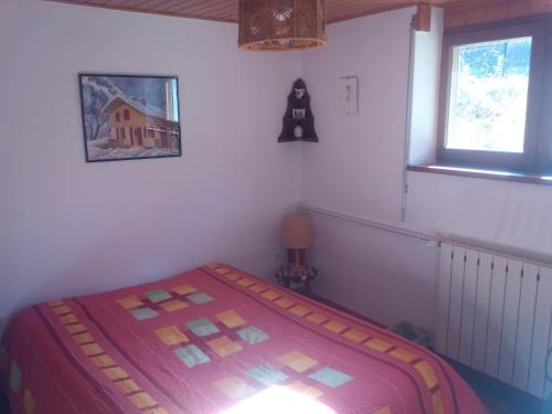 1 dormitorio con 1 cama en una habitación con ventana en appartement en duplex dans un chalet typique, en Valloire