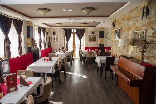 科帕奥尼克Apartman Nena b15的一间带桌椅和钢琴的餐厅