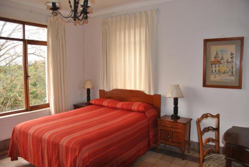 a bedroom with a red bed and a window at Hotel Gloria Coroico in Coroico