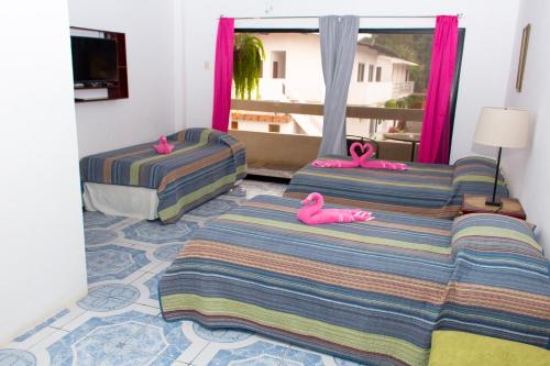 a bedroom with two beds with pink flamingos on them at Hostería "El Paraíso" in Montañita
