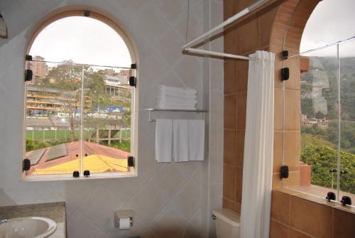 baño con ducha y ventana en Hotel Gloria Coroico, en Coroico