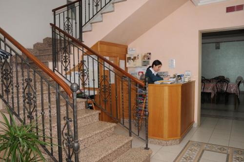 a woman standing at a counter in a building at Hotel Meridiana in Arbus
