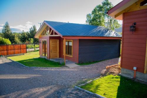 a small house with a garage next to a driveway at Cabañas Cerro Huemules in Coihaique