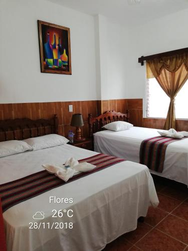 a hotel room with two beds with towels on them at Hotel La Union in Flores