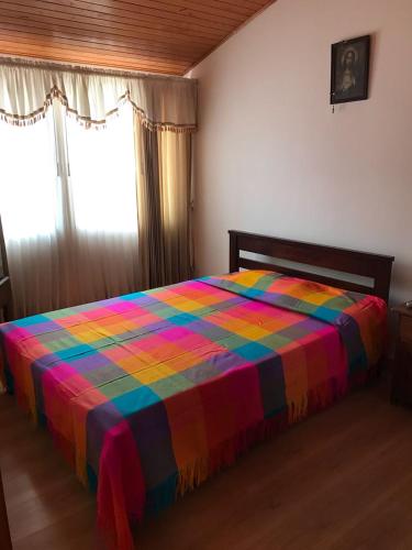 a bed with a colorful blanket on it in a room at Casa campestre Isabelita in Tibasosa