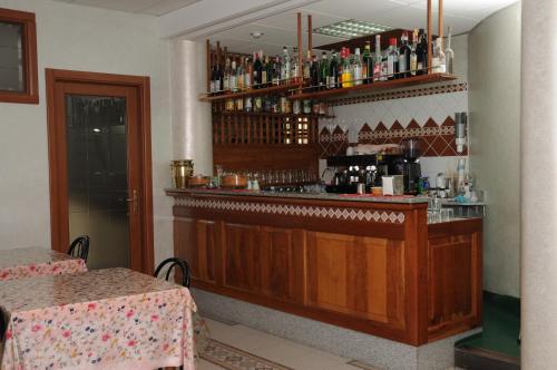 a bar in a restaurant with a counter with drinks at Hotel Meridiana in Arbus