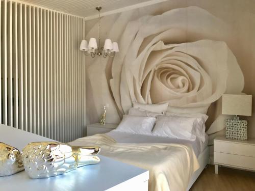 a bedroom with a large white bed with a flower carved into the wall at Pedacinho de Mundo Douro in Passinhos de Cima