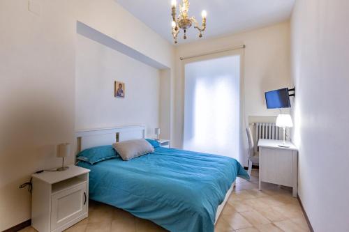 a bedroom with a blue bed and a chandelier at Istituto SS Salvatore in Orvieto