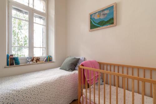a bedroom with a crib and a window at The Pearl in Talbyeh in Jerusalem