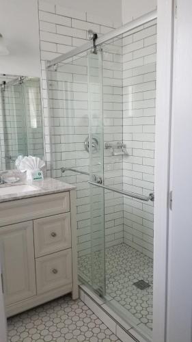 a bathroom with a shower with a glass door at The Palms Hotel in Key West