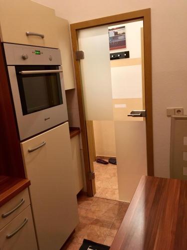 a kitchen with a refrigerator and a door to a room at Villa Linde Franke in Bernburg