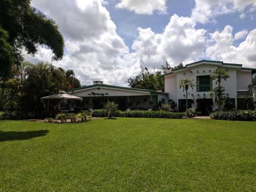 a house with a lawn in front of it at Casa Finca Paititi in San Antonio de Pereira
