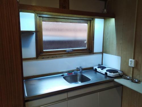 encimera de cocina con fregadero y ventana en Two Rooms Rustic House - Self Check-In, en Bucarest