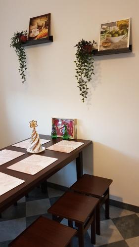 a table with benches and pictures on the wall at Apartament Angelo in Sosnowiec