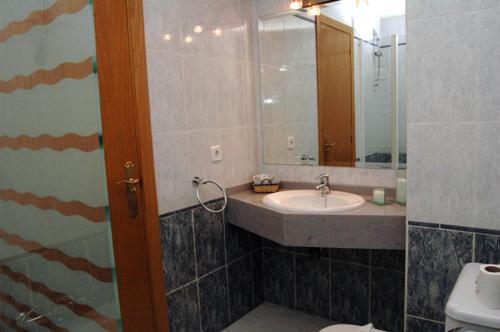 a bathroom with a sink and a mirror at Hostal Stop in Cantalejo