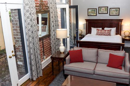 a living room with a bed and a couch at East Bay Inn, Historic Inns of Savannah Collection in Savannah