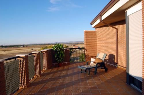 a balcony with a bench on a brick building at Hostal Stop in Cantalejo