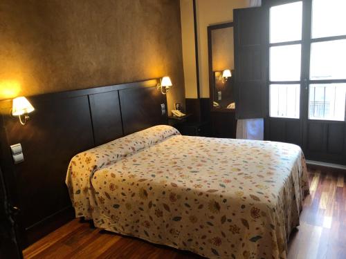 a bedroom with a bed with a floral bedspread at Hosteria Casa Vallejo in Salamanca