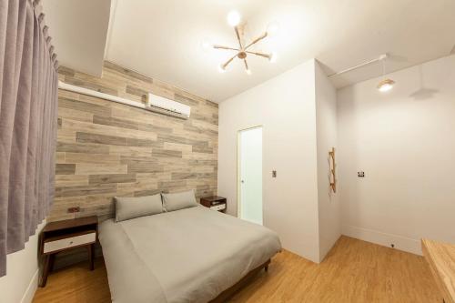 Un dormitorio con una cama y una pared de ladrillo. en Slow Inn, en Tainan