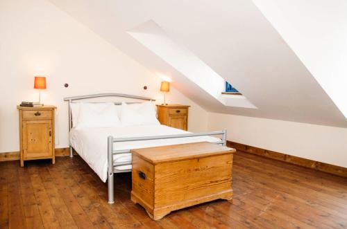 um quarto com uma cama e piso em madeira em Hay Barn em New Mills