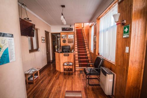 a room with a staircase and a living room with a television at Hostal Chalet Las Violetas in Punta Arenas