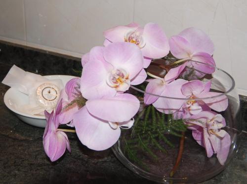 a glass vase filled with purple flowers on a counter at Astoria Hotel Italia in Udine