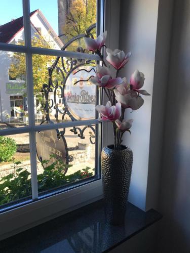 a vase with pink flowers sitting in a window at Hotel zum Braunen Hirschen in Bad Driburg