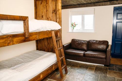 ein Schlafzimmer mit Etagenbetten und einem Sofa in der Unterkunft The Bike Shed in New Mills