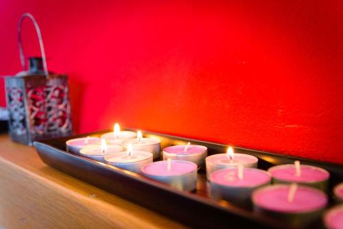 a group of candles sitting on a table with a red wall at CasaJona Holiday in Poggibonsi