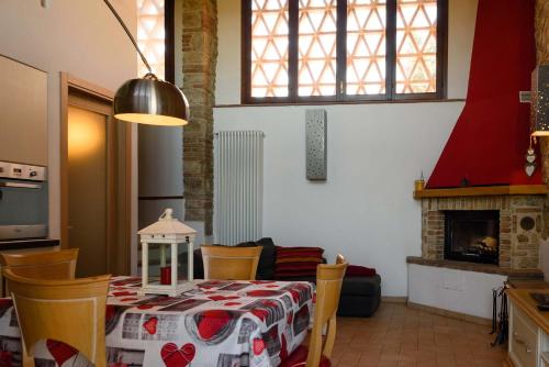a dining room with a table and chairs and a fireplace at CasaJona Holiday in Poggibonsi